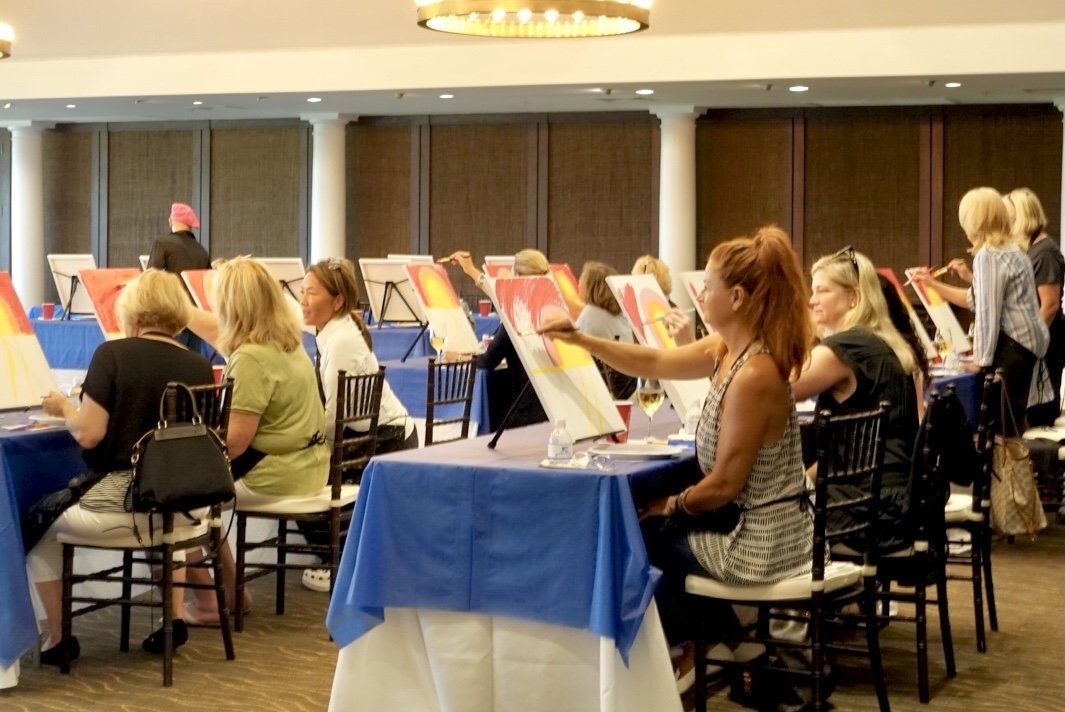Guests painting during an interactive event painting class