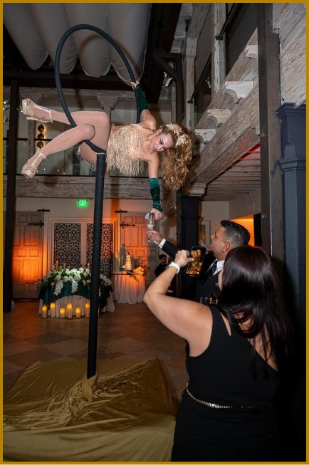 Cirque aerialist performing silks above the event floor