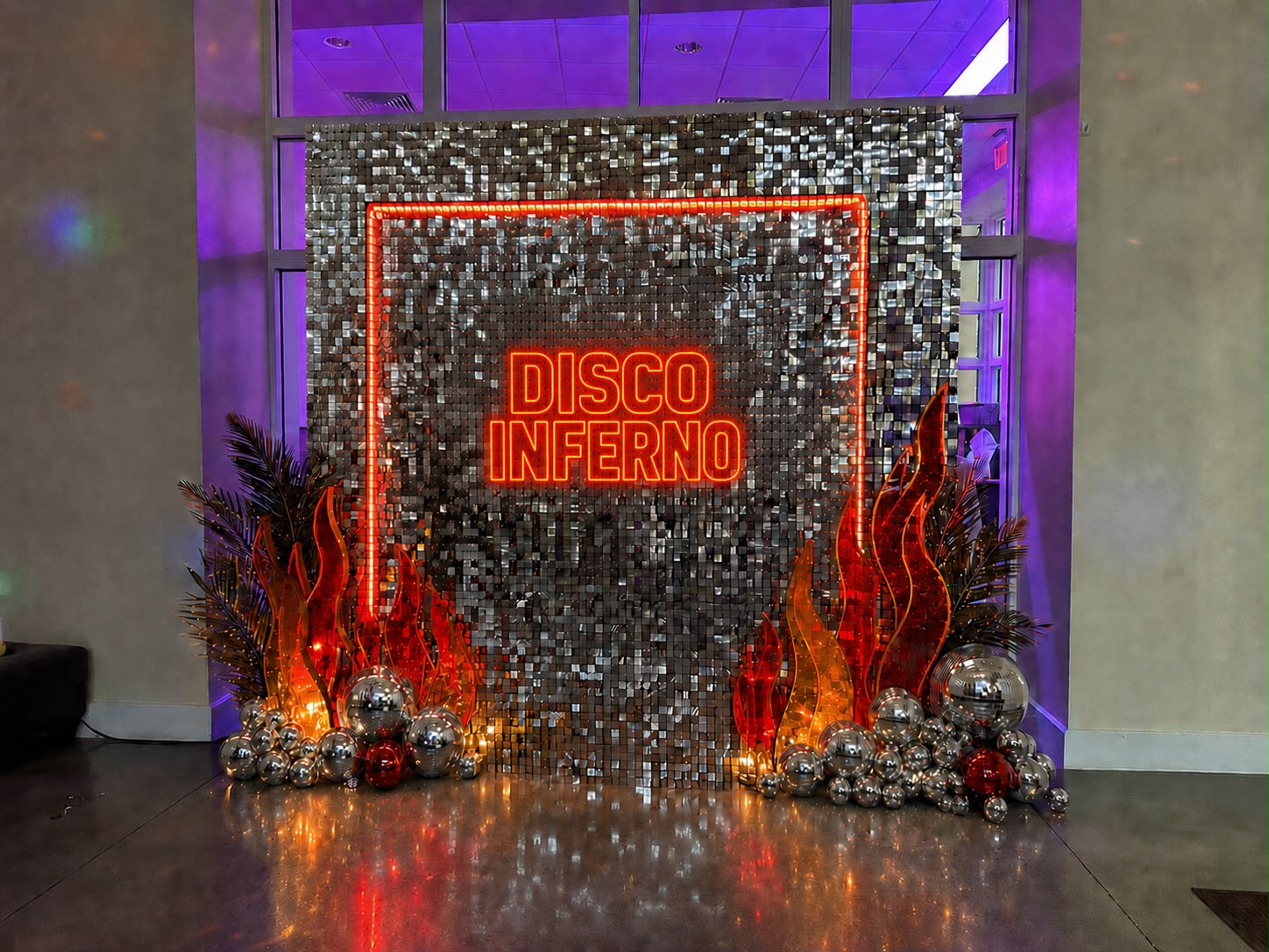 Disco Inferno sequin wall with neon signage and custom flame props