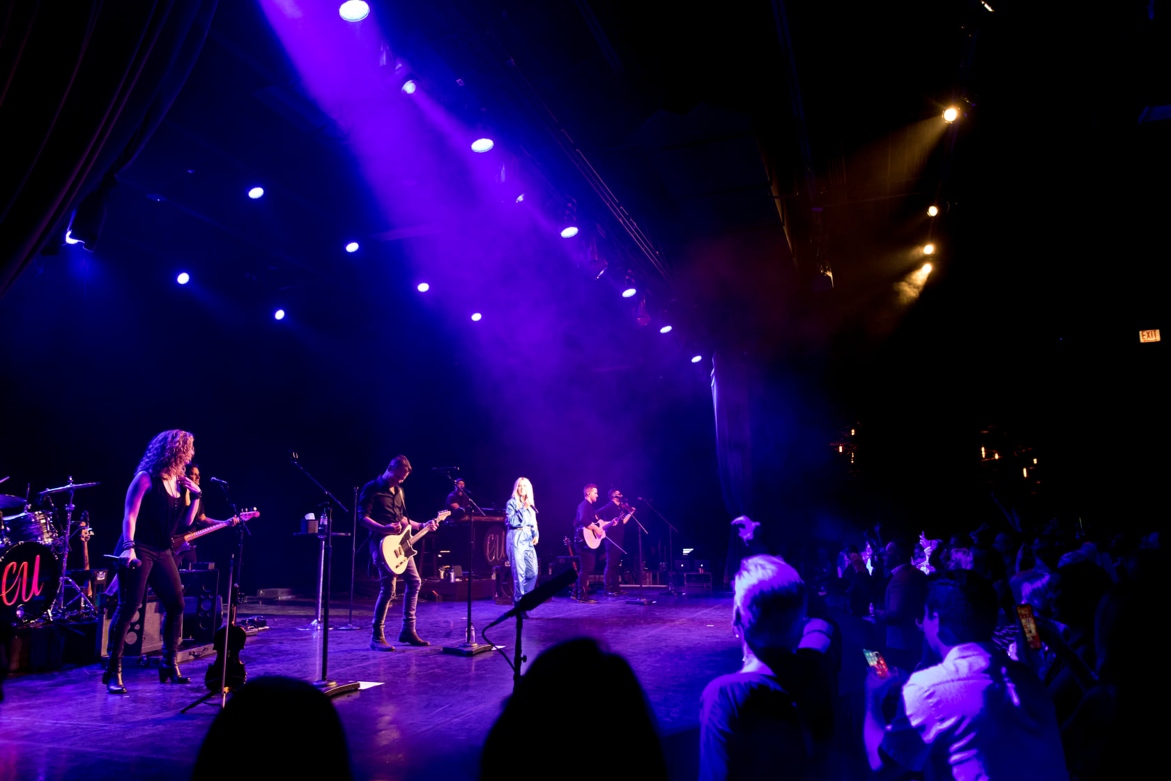 Full headliner band performing on a purple-lit concert stage