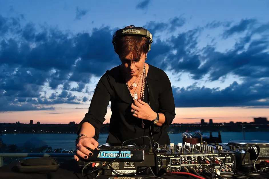 DJ Tracy Young performing on the decks at a private event at dusk