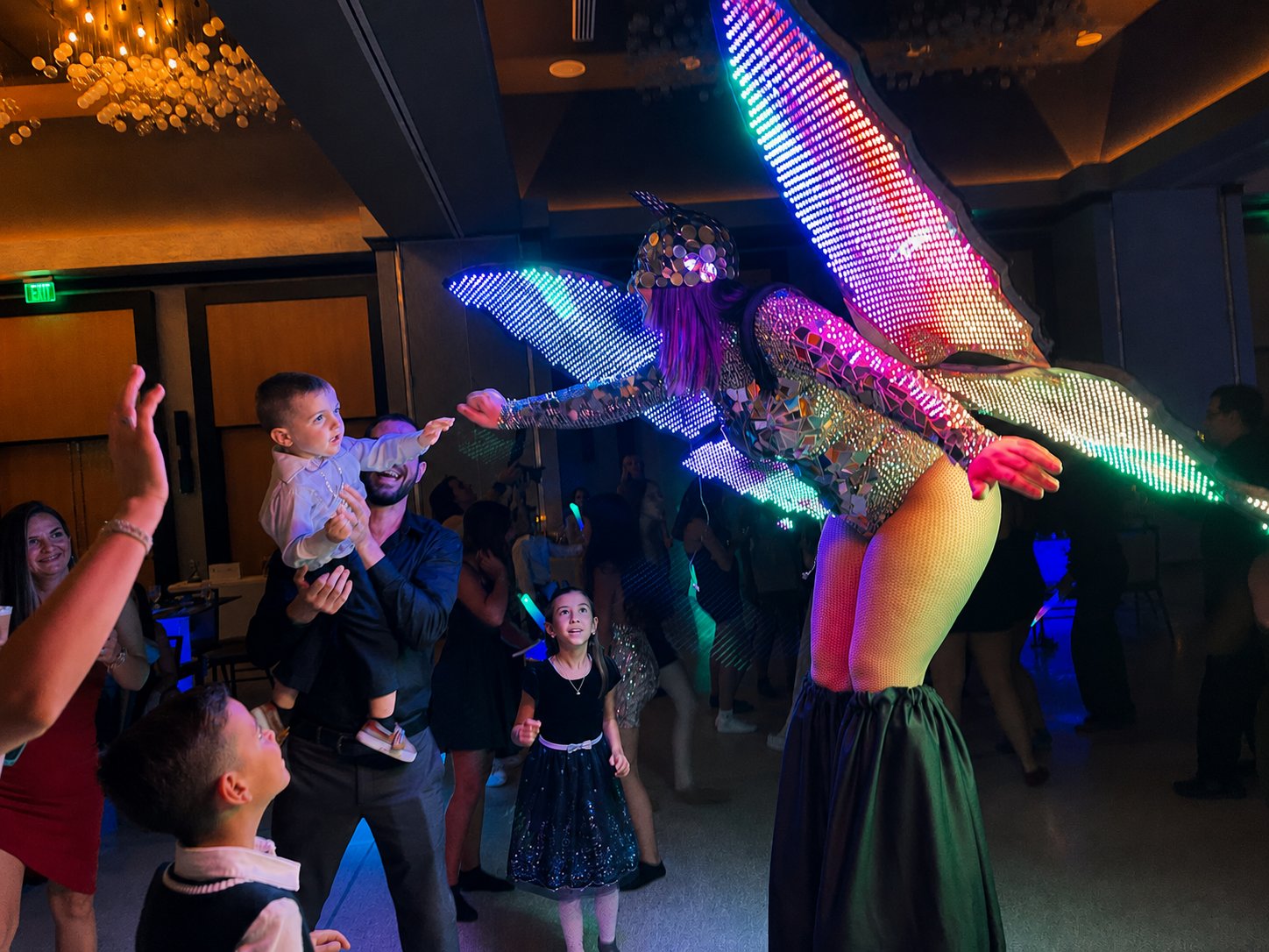 LED butterfly stilt walker entertaining guests