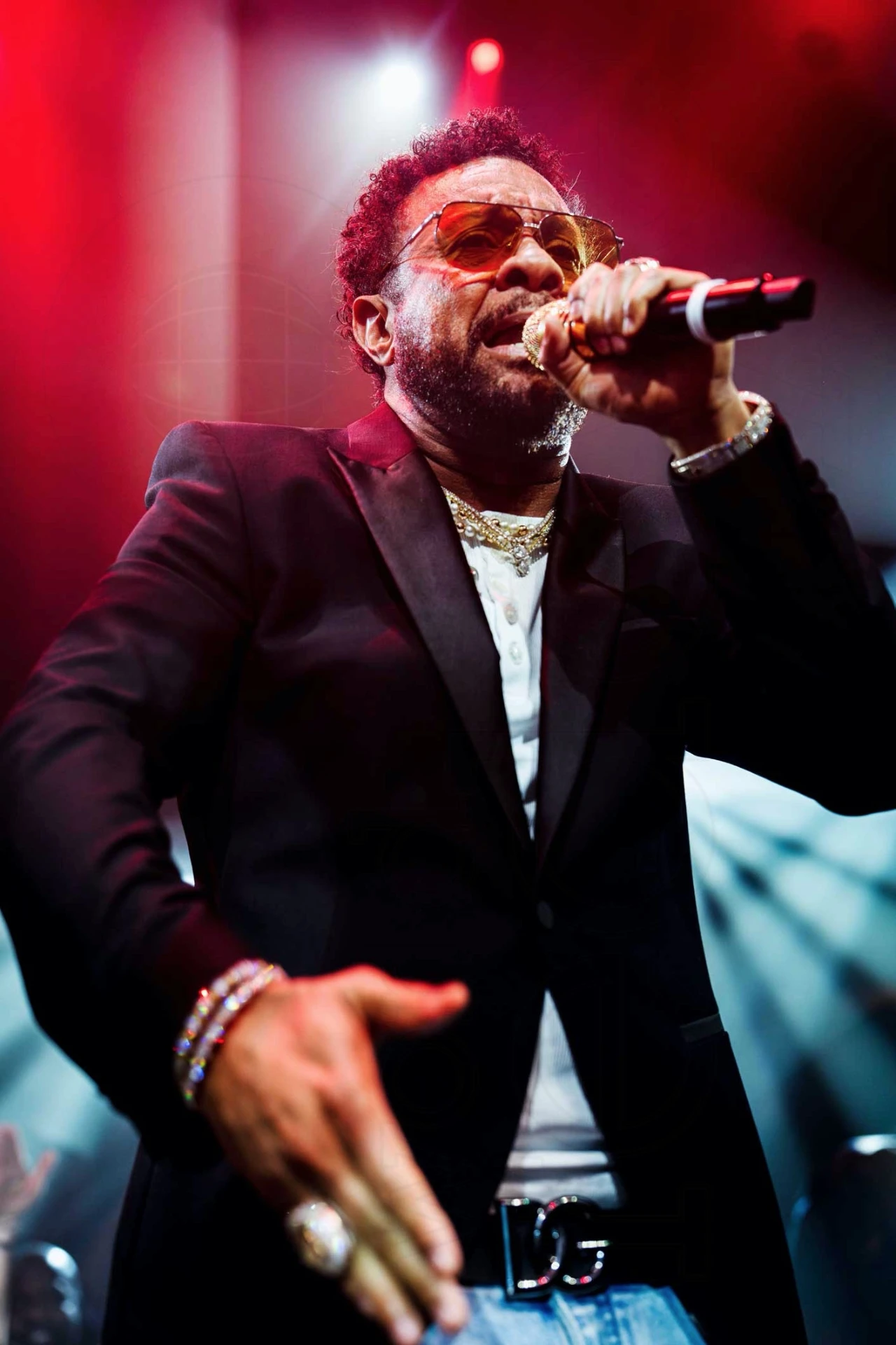 Shaggy performing live on stage under red stage lighting at a private event