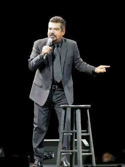 George Lopez performing his stand-up set on stage at a private event