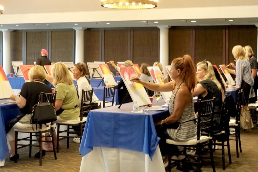 Guests at an interactive paint and sip painting experience