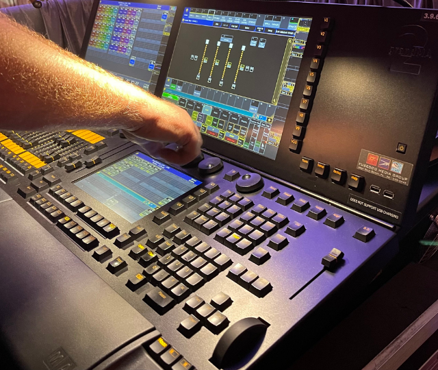 Professional lighting console programming a produced event's stage and effects