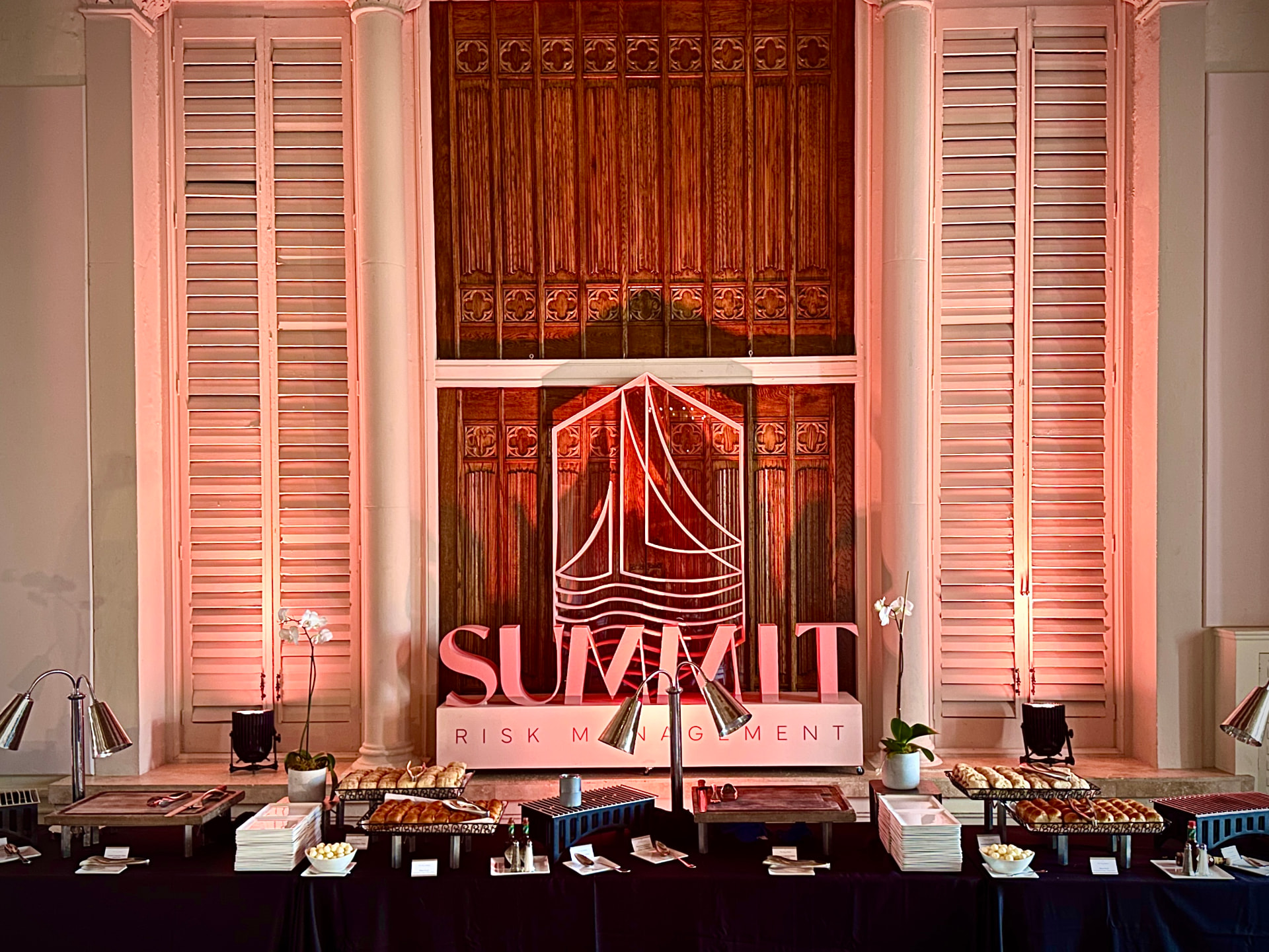 Custom fabricated Summit Risk Management logo sculpture under warm uplighting