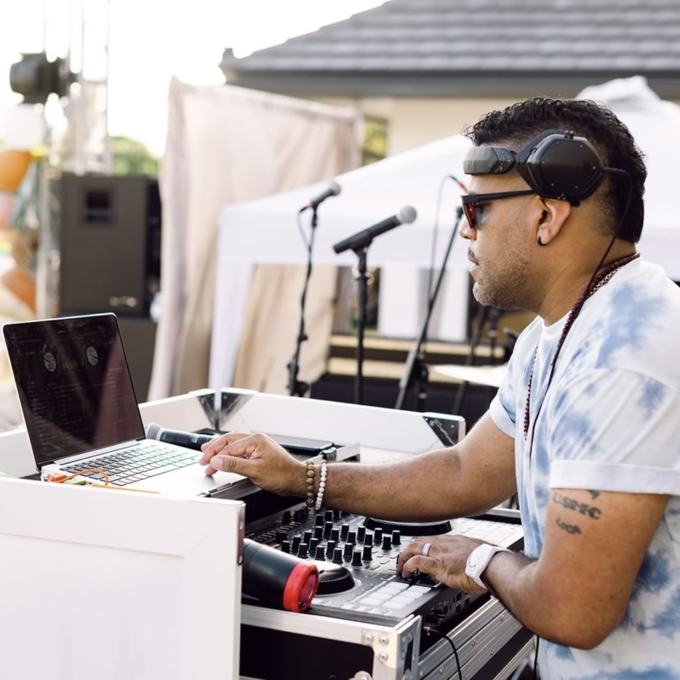 DJ 808 performing behind a custom lit booth
